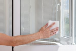 Houseworker cleans window